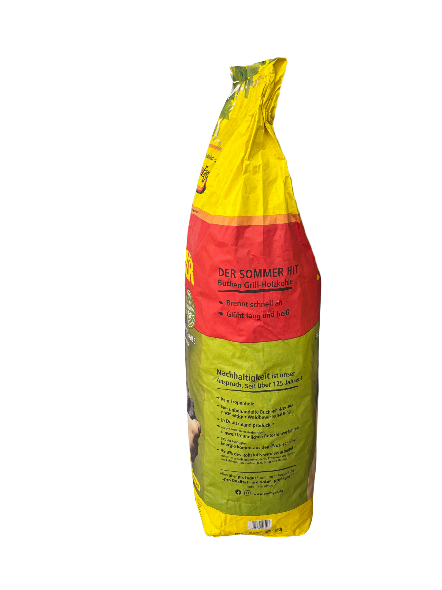 Seitenansicht eines gelb-rot-grünen Beutels Profagus Buchen Grill-Holzkohle, 'DER SOMMER HIT'. Sichtbar sind Teile der Vorderseite sowie die Seitenwand mit Texten wie 'Brennt schnell ab', 'Glüht lang und hell' und Abschnitten zur Nachhaltigkeit, darunter 'Nachhaltigkeit ist unser Anspruch. Seit über 125 Jahren!'.