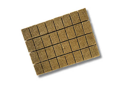 Eine rechteckige Platte mit 32 einzelnen, braunen Grillanzünderwürfeln, die noch miteinander verbunden sind, bereit zum Abbrechen.